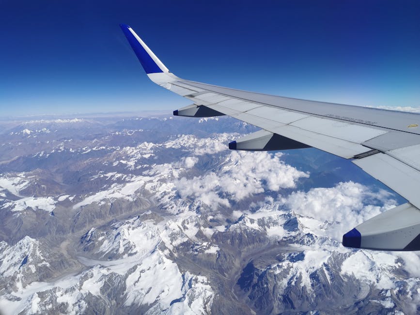Himalayan mountain range viewed through the wing of a plane window