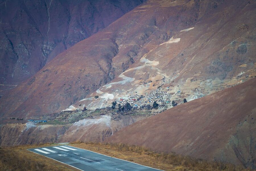 Mountain airstrip in Karnali Province, Nepal, with small aircraft and hillside village