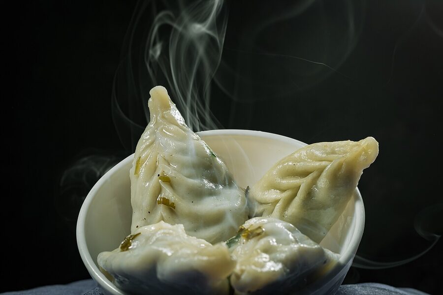Plate of steamed Nepali momos with dipping sauce